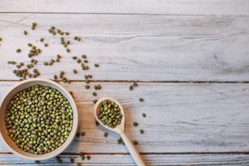 Green mung beans in bowl on the white wooden table