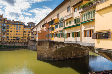 Fototapeta na wymiar Ponte Vecchio in historical center downtown in Florence during a sunny day with historical old buildings