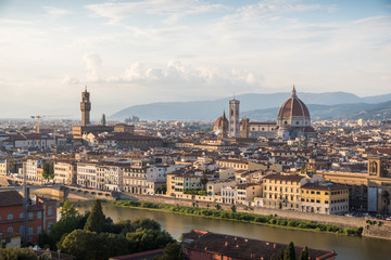 Fototapeta na wymiar Florence romantic panoramic view from above during a coloured sunset on buildings Duomo churches and Ponte Vecchio