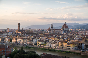 Fototapeta na wymiar Florence romantic panoramic view from above during a coloured sunset on buildings Duomo churches and Ponte Vecchio