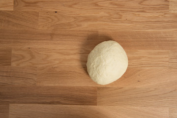 Wheat dough rising on a wooden table