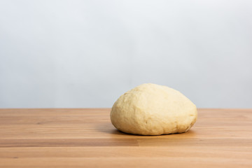 Fototapeta na wymiar Wheat dough rising on a wooden table