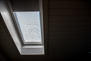 Roof window seen from the inside on a cold day.