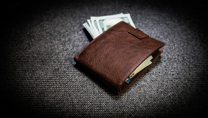 Stylish men's purse with money on wood background.