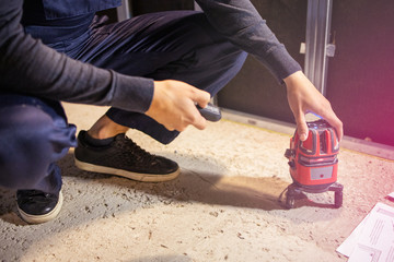 Man using electronic laser level. Carpenter measuring the levell. Horizontal. Renovation at home. Building construction indoor. ..