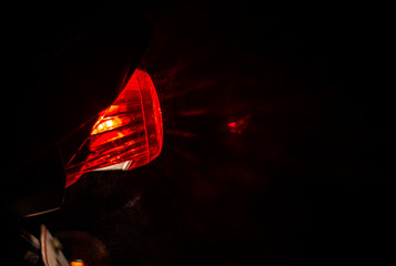 Red tail break light of a two wheeler sprayed with water droplets and the reflecting showers of water