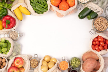 Zero waste concept. Fruits and vegetables in eco friendly reusable cotton bags. Top view with copy...