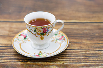 Cup of tea with macaroons on pink background