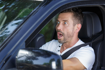 a shocked male driver in his car