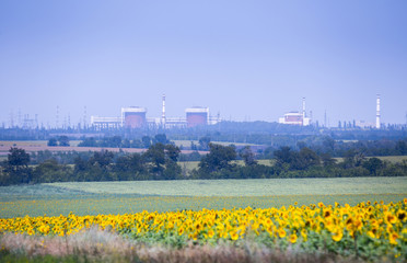 View on South Ukraine Nuclear Power Plant. Station is located near the city of Yuzhnoukrainsk in Mykolaiv region, Ukraine. Sunflower field in the foreground.
