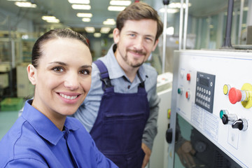 engineer and apprentice examining a machine in factory