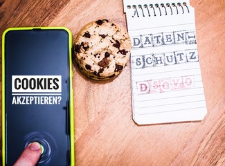 Cookies mit einem Tablet zur Verdeutlichung von Cookie Bannern für Websites mit auf deutsch...