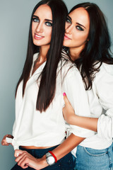 two sisters twins girl posing, making photo selfie, dressed same white shirt, diverse hairstyle friends, lifestyle people concept