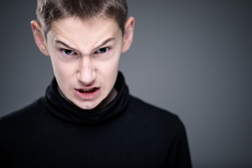 Loads of aggression in a little boy - education concept hinting behavioral problems in young children (shallow DOF) - little boy with hands clenched into fists about to punch someone