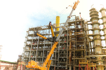 Construction and installation work with a powerful construction crane of a large new industrial oil...