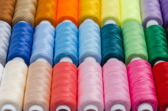 sewing threads different colors, very colorful in background, colorful background