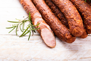 Rings of traditional smoked sausage on wooden boards, top view.
