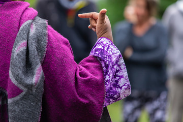Closeup of female wearing full sleeve purple dress while gesturing telling story during festival at...