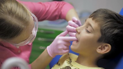 Child patient sitting on dental chair in paediatric dentists office