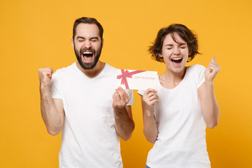 Joyful couple friends bearded guy girl in white blank empty t-shirts isolated on yellow orange...