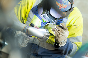 welding man welding pipe in industry