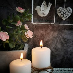 Two burning candles on a dark background. 