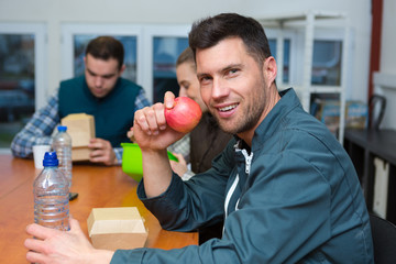 male manual worker eating apple for lunch