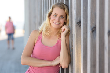 a happy woman leaning on wall