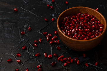 bowl with pomegranate seeds on dark background