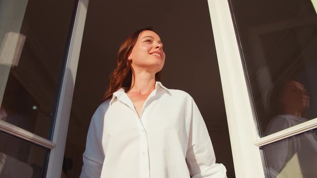 Young girl opening a window in the morning