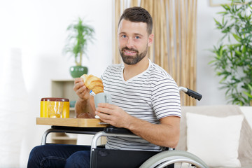 relaxed handsome man in wheelchair drinking coffee