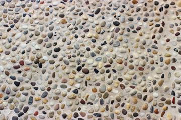 Stone wall texture, road made of small round and sea stones