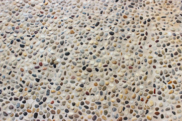 Stone wall texture, road made of small round and sea stones