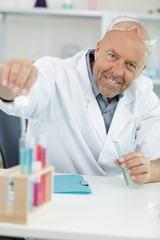 happy man holding a test-tube at the laboratory