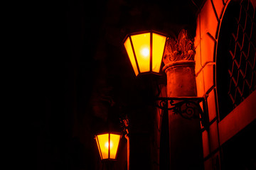 Old street lantern on a wall at night