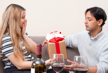 Cute young latin couple exchanging gift for valentines day