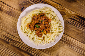 Pasta with bolognese sauce in a ceramic plate. Top view