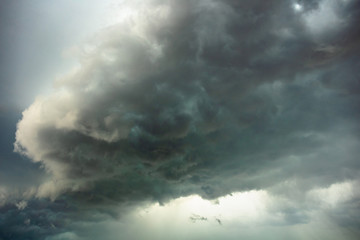 big bright thundercloud in a gray dark blue stormy sky
