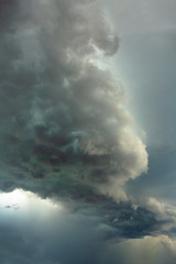 big bright thundercloud in a gray dark blue stormy sky