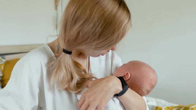 Caucasian mom calms a crying baby while holding in her arms