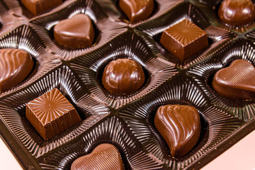 Heap of chocolate candies in a brown box