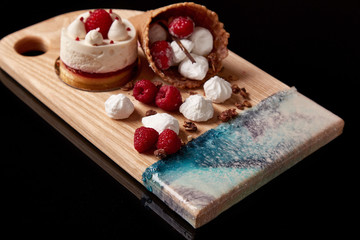 Exclusive painted art cutting board made of wood organic serving dishes with taste food cuisine waffles with sweet candy cream raspberry berry ice sugar cake waffle.