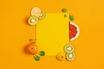 Composition of citrus fruit, orange, lemon and kiwi on yellow background