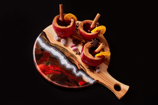 Exclusive painted art cutting board made of wood organic serving dishes with taste food cuisine hot drink wine juice fruit apple with cinnamon spice citrus orange winter mood.