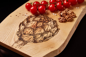 Exclusive painted art cutting board made of wood organic serving dishes with taste food cuisine delicious juicy vegetables red tomato onion avocado mushroom and nuts.