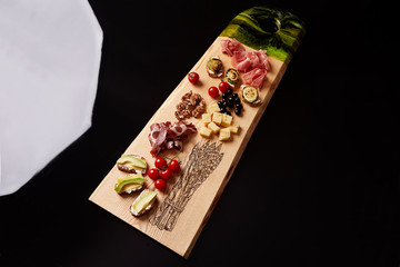 Exclusive painted art cutting board made of wood organic serving dishes with taste food cuisine delicious snack toast cream with cheese and vegetables avocado tomato jamon meat nuts olive.