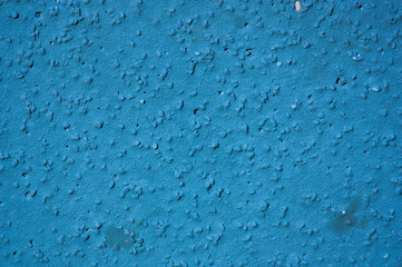 Close-up of a rugged blue wall with a grainy texture