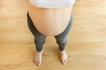high angle shot of a pregnant woman’s bare belly