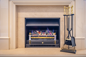Gas fired classic looking fireplace with tools on the side