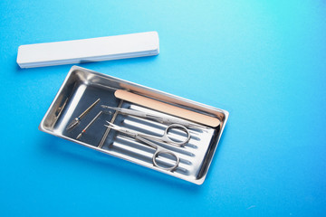 manicure tools on a blue background.scissors, pusher, cutter, saw, machine